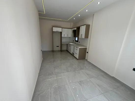 Gümüldürde Merkezi Lokasyonda Bahçeli Asansörlü Denize 400m Satılık 1+1 Daire
